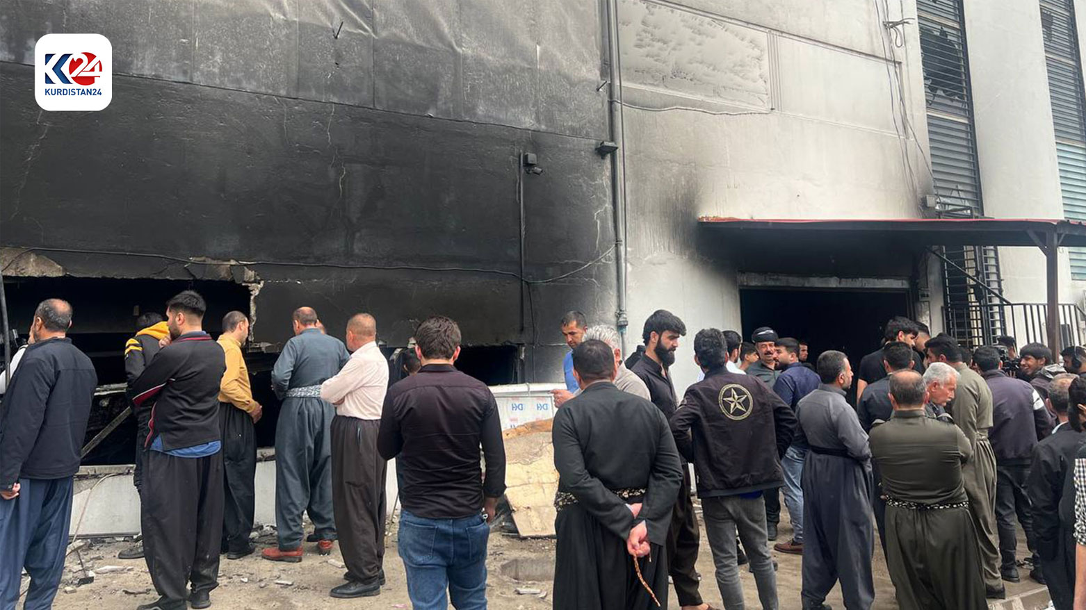 The scene of the burnt shopping mall in Arbat, Sulaimani, as people and shop-owners inspect the premises. (Photo: Kurdistan 24)