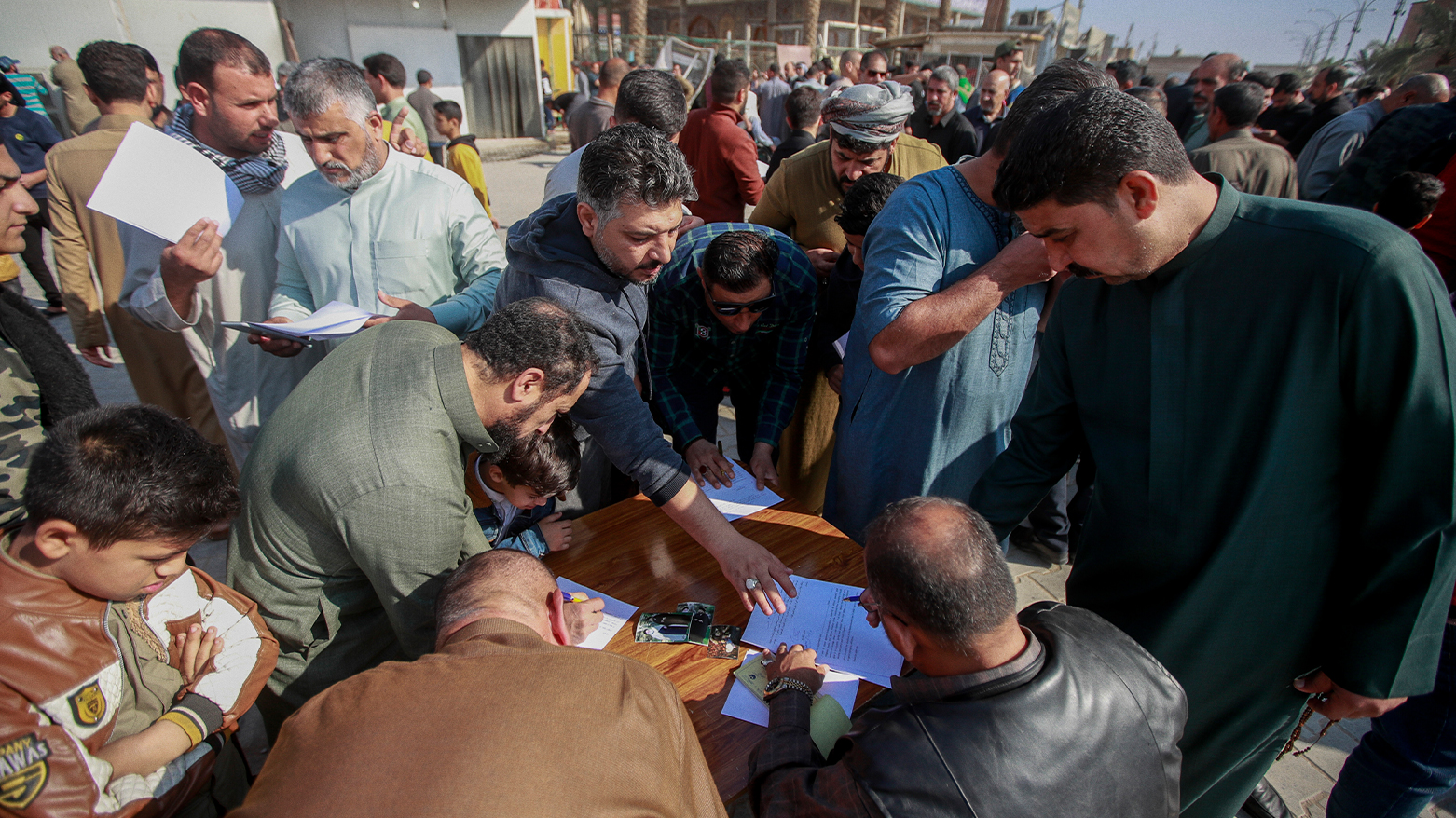 Supporters of the Shiite cleric Muqtada al-Sadr sign a pledge to stand against homosexuality or LGBTQ, outside a mosque in Kufa, Iraq, Friday, Dec. 2, 2022. (Photo: AP)