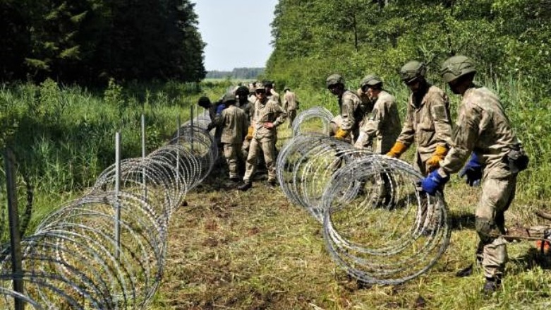 Lithuanian border guards build a 550-kilometer barbed wire fence on its border with Belarus. (Photo: Janis Laizans/Reuters)