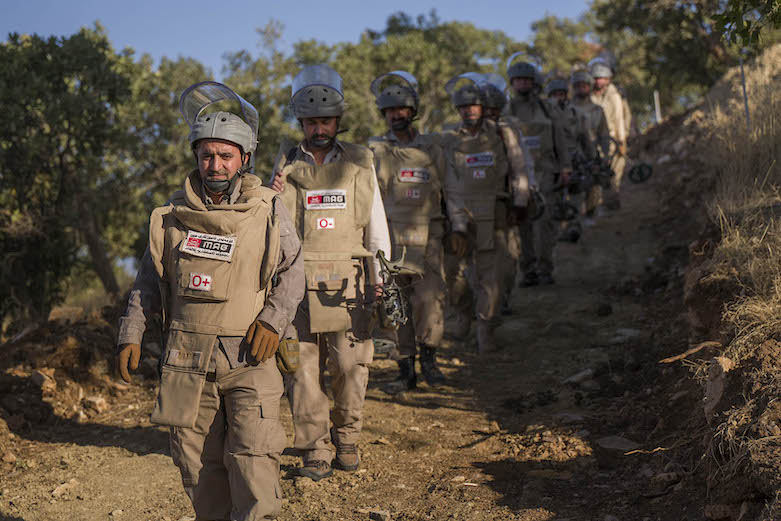 MAG deminers head to the minefield above Wilyawa village (Photo: Sean Sutton/MAG)