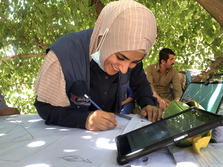 MAG community liaison Gona Hassan updates a map of minefields around Wilyawa, July 5, 2021. (Photo: Mahnaz Lashkri/MAG)