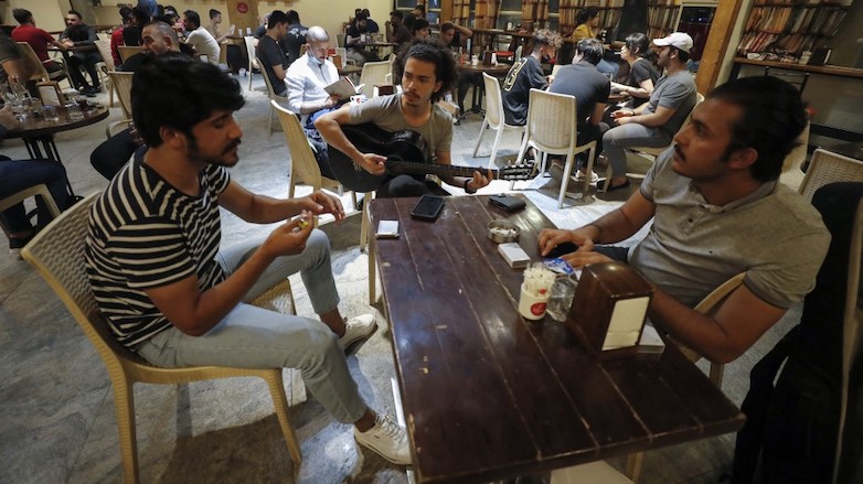 Iraqi guitarist Mohammed, 23, plays as he sits with his friends at a coffee shop in the Karrada district of the capital Baghdad, August 6, 2021. (Photo: Ahmad Al-Rubaye/AFP)