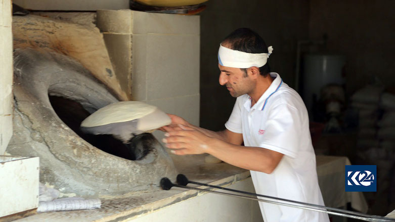 A baker prepares naan (bread) for a customer. (Photo: Kurdistan 24)