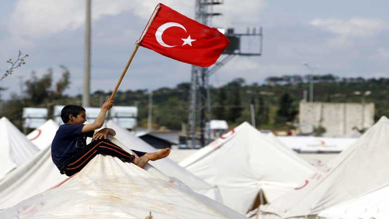 A boy raises a Turkish flag in a displacement camp in Iraq. (Photo: Archive)
