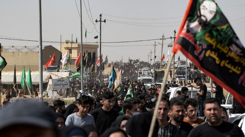 Iraqi pilgrims walk toward the shrine of Imam Zayn al-Abidin in the northern city of Mosul, on the tenth day of the month of Muharram which marks the peak of Ashura, on August 19, 2021. (Photo: Zaid AL-Obeidi / AFP)