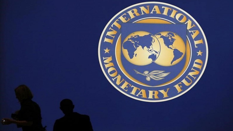 Visitors are silhouetted against the logo of the IMF at its annual meeting with the World Bank in Tokyo. (Photo: Reuters)
