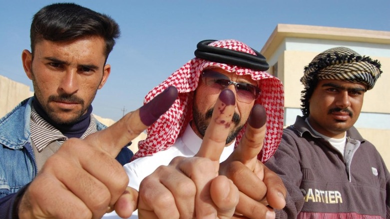 Iraqi males show their ink-stained fingers after casting their votes at a polling station in 2010. (Photo: AFP)