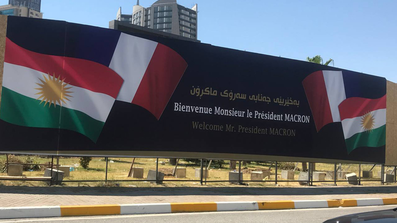 لوحة كُتب عليها "مرحباً بالسيد الرئيس ماكرون" (تصوير: هوشمند صادق/ كوردستان 24)