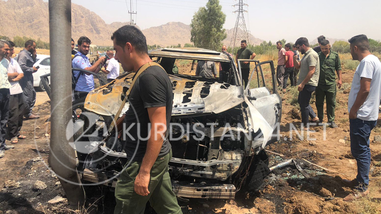 Security forces and onlookers at the site of the strike that destroyed the Toyota Land Cruiser, Aug. 1, 2022 (Photo: Aras Amin/Kurdistan 24)