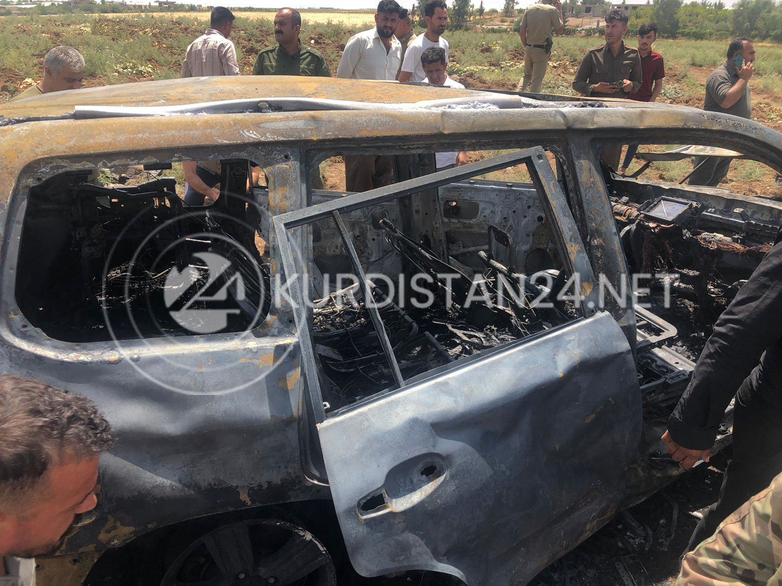 Security forces and onlookers at the site of the strike that destroyed the Toyota Land Cruiser, Aug. 1, 2022 (Photo: Aras Amin/Kurdistan 24)