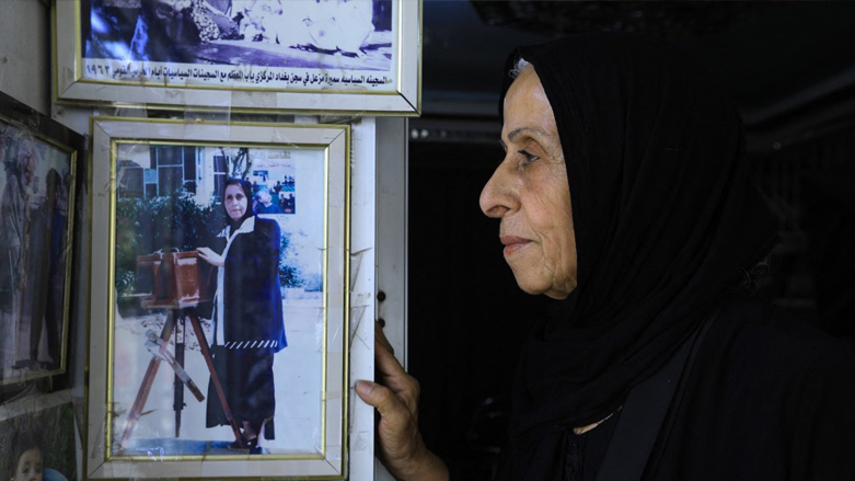 Iraqi photographer Samira Mazaal poses for a picture next to framed images retracing her career at her studio in the city of Amarah in Iraq's southeastern Maysan province , July 9, 2022. (Photo: Asaad Niazi/AFP)