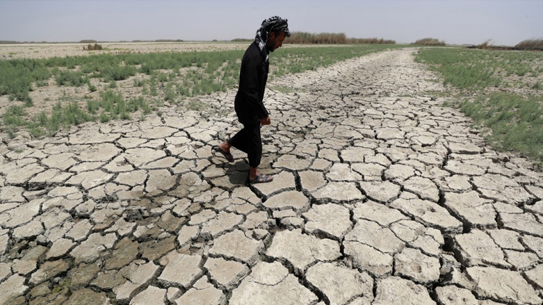 A man walks on cracked and dried up soil in the Hawiza marsh near the city of al-Amarah in southern Iraq, July 27, 2022. (Photo: Ahmad Al-Rubaye/AFP)