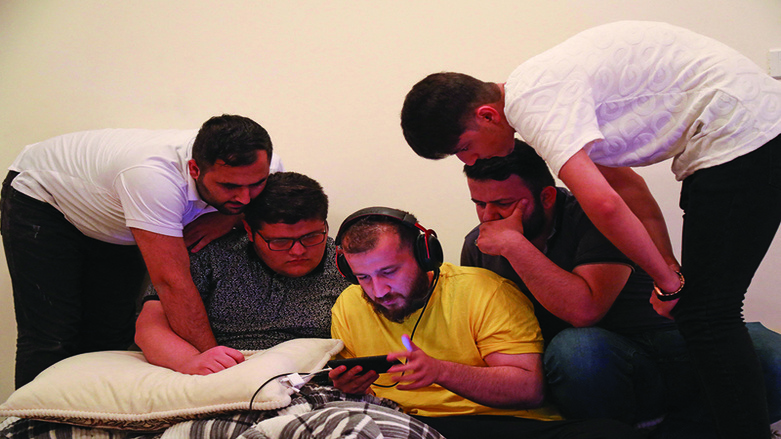 Kurdish youths play the PUBG video game on a mobile phone in Kurdistan Region's Erbil, May 17, 2021. (Photo: Safin Hamed/AFP)