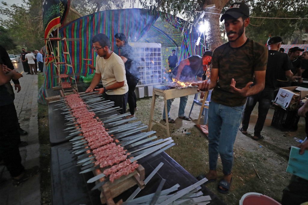 Iraqi volunteers prepare food for supporters of Shiite cleric Moqtada Sadr, as they continue to protest against the nomination of a rival Shiite faction for the position of prime minister, outside the Iraqi parliament building in the Green Zone of the capital Baghdad, on August 16, 2022. 