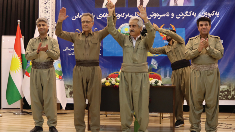 Khalid Azizi, Secretary General of the KDP-I (left), and Mustafa Hijri, Secretary General of the PDK-I (right) hold hands in a sign of unity (Photo: Kurdistan u Kurd.)