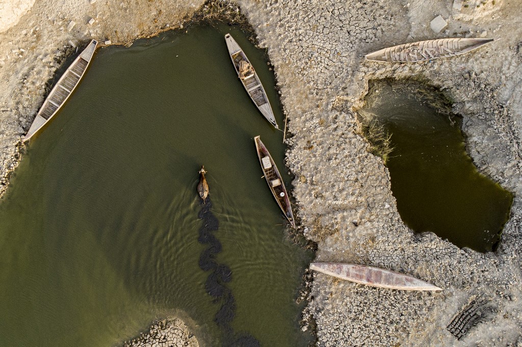 Aerial view shows a buffalo swimming near fishing boats in Iraq's receding southern marshes of Chibayish in Dhi Qar province August 23, 2022. (Photo: Hussein Faleh/AFP)