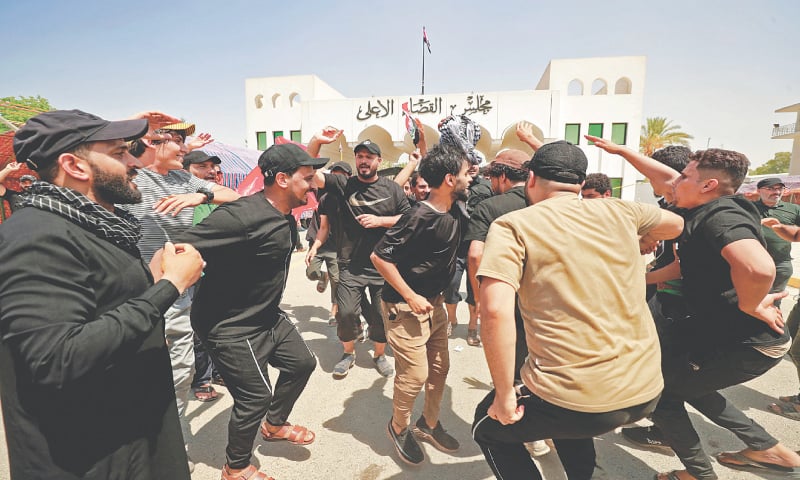 Supporters of Moqtada al-Sadr dance during a protest outside the headquarters of the Supreme Judicial Council in Baghdad, August 23, 2022 (Photo: AFP)