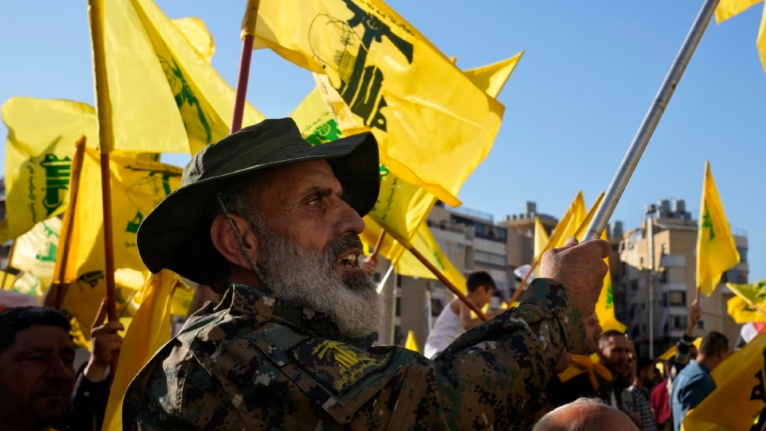 A Hizballah fighter waves his group's flag as he attends an election rally in a southern suburb of Beirut, Lebanon, May 10, 2022 (Photo: AP)