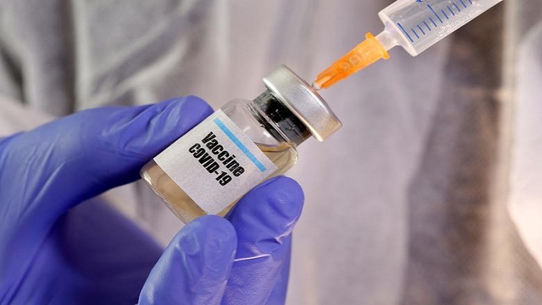 A woman holds a small bottle labeled with a "Vaccine COVID-19" sticker and a medical syringe in this illustration taken April 10, 2020. (Photo: REUTERS/Dado Ruvic)
