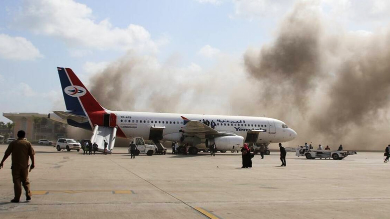 People walk on the tarmac as dust and smoke rise after explosions hit Aden airport, upon the arrival of the newly-formed Yemeni government, Dec. 30, 2020. (Photo: Reuters/Fawaz Salman)