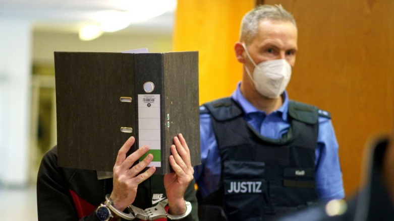 The Iraqi defendant covers his face before sentencing in a courtroom in Frankfurt, Nov. 30. (Photo: Frank Rumpenhorst/Reuters)