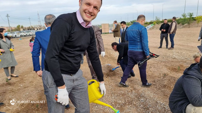 UK Deputy Consul General Jamie Hamill waters a tree (Photo: Wladimir van Wilgenburg/Kurdistan 24).