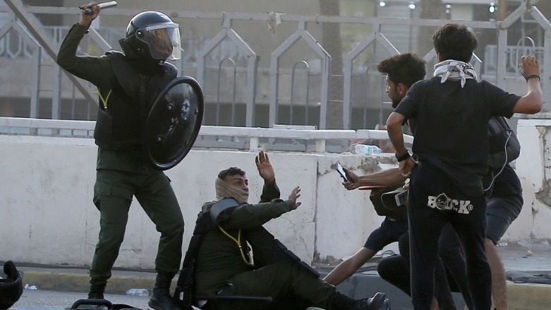 A member of security forces tries to protect himself amid a clash with demonstrators during an anti-government protest in Baghdad, Iraq May 25, 2021. (Photo: REUTERS/Thaier Al-Sudani)