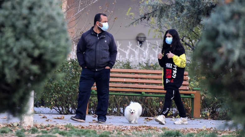 An Iranian father and his daughter walk their dog in a park in the capital Tehran, on December 7, 2021. (Photo: ATTA KENARE / AFP)