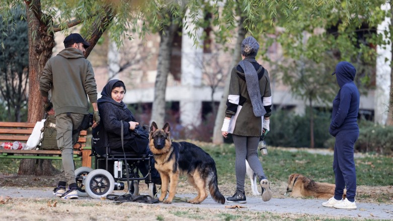 Iranians play with their dogs at a park in the capital Tehran, on December 7, 2021.