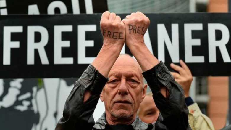 A man holds up his fists with Free Press written in black marker across them. (Photo: Archive)