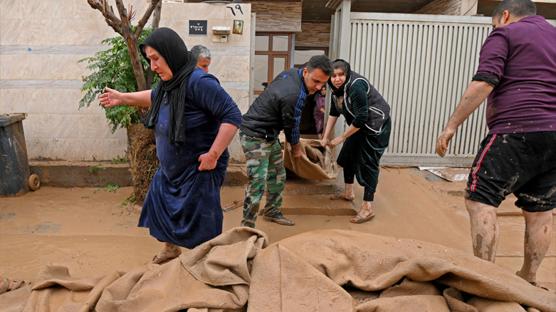 Residents clear debris from flooding in the Daratu district of Erbil province, Dec. 17, 2021. (Photo: AFP)