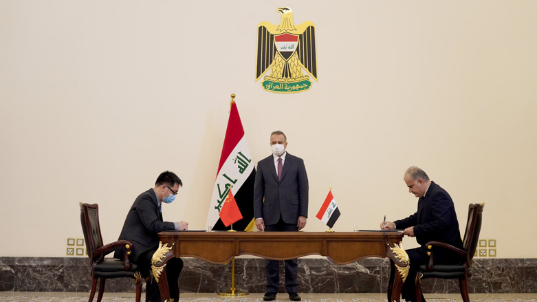 Iraqi Prime Minister Mustafa Al-Kadhimi stands (center) while an Iraqi official signs a deal for the construction of new schools with a Chinese company official in Baghdad, Dec. 16, 2021. (Photo: Iraqi Government)