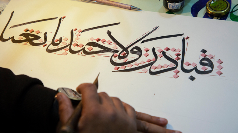 Iraqi calligrapher Wael Ramadan uses a stylus to produce a sample of Arabic calligraphy at his workshop in al-Ashar district of Iraq's southern city of Basra, Dec. 21, 2021. (Photo: Hussein Faleh/AFP)