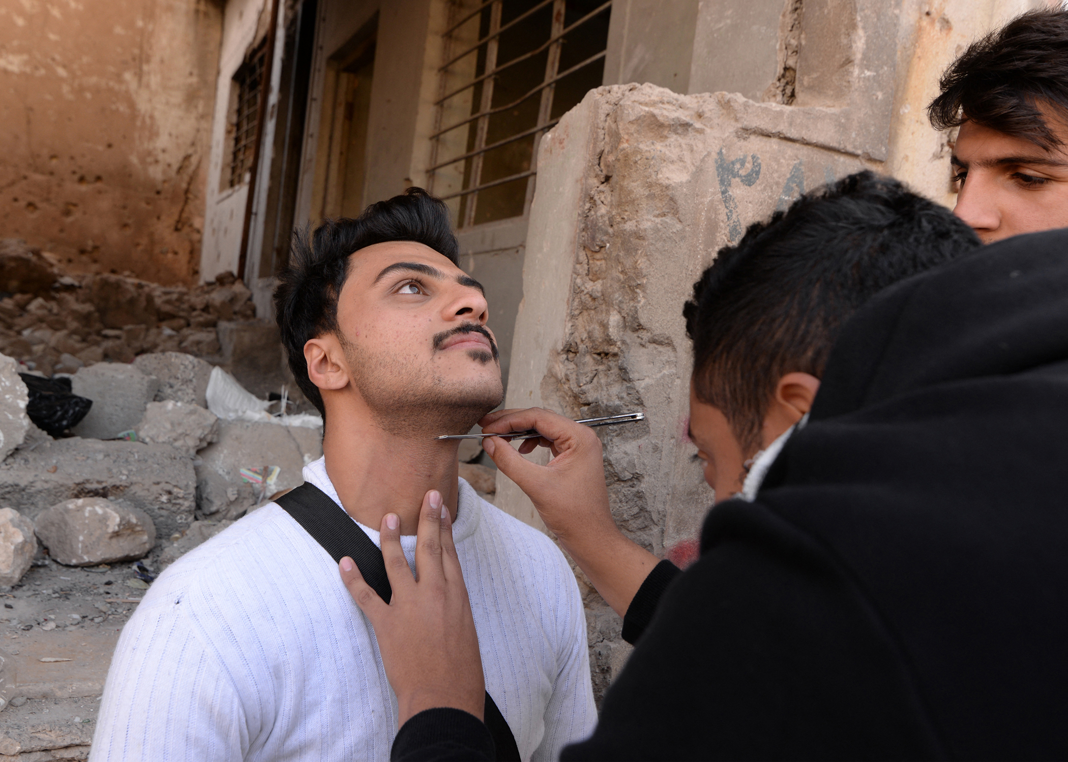 Makeup artists of a film school, prepare an actor before shooting a scene, in the war-ravaged northern Iraqi city of Mosul, Dec. 15, 2021. (Photo: Zaid al-Obeidi/AFP)