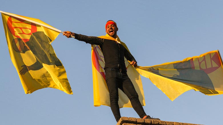 A Kurdistan Democratic Party (KDP) supporter waving his party's yellow flag during an election rally at Erbil Citadel, Oct. 7, 2021. (Photol: Safin Hamed/AFP)