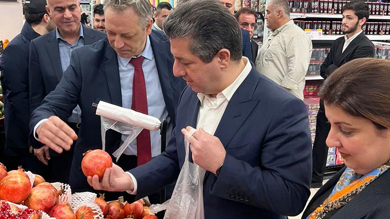 PM Barzani (middle) picking a pomegranate during his visit to Family Mall, Erbil on Dec. 3, 2022. (Photo: Kurdistan 24)