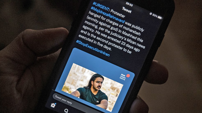 A mobile phone, displaying a Tweet about the execution announced by Iranian authorities of Majidreza Rahnavard, the second capital punishment linked to nearly three months of protests, Dec. 12, 2022. (Photo: AFP)