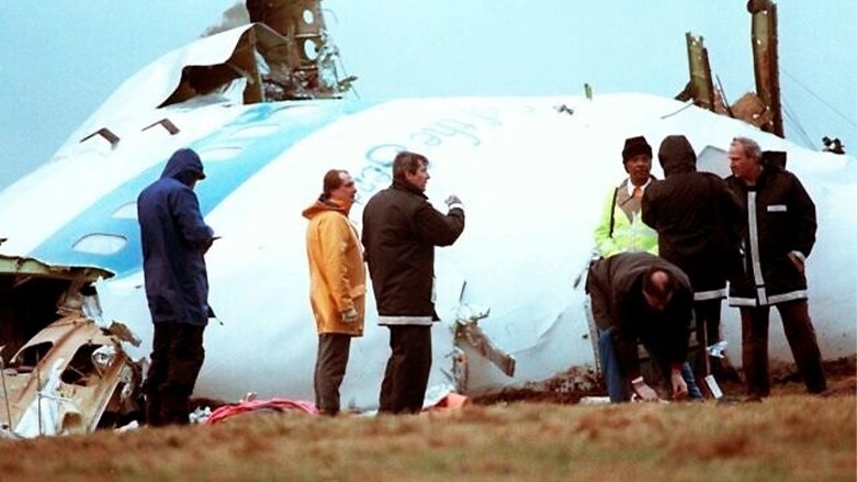 Unidentified crash investigators inspect the nose section of the crashed Pan Am flight 103, a Boeing 747 airliner in a field near Lockerbie, Scotland, December 23, 1988. (Dave Caulkin/AP)