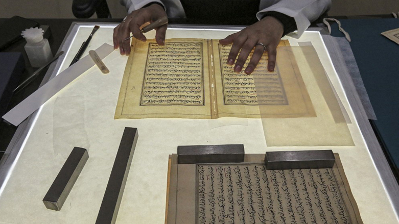 A conservator pieces together a Turkish-language manuscript undergoing restoration at the Iraqi Manuscript House's resoration lab in Iraq's capital Baghdad, Dec. 6, 2022. (Photo: Sabah Arar/AFP)