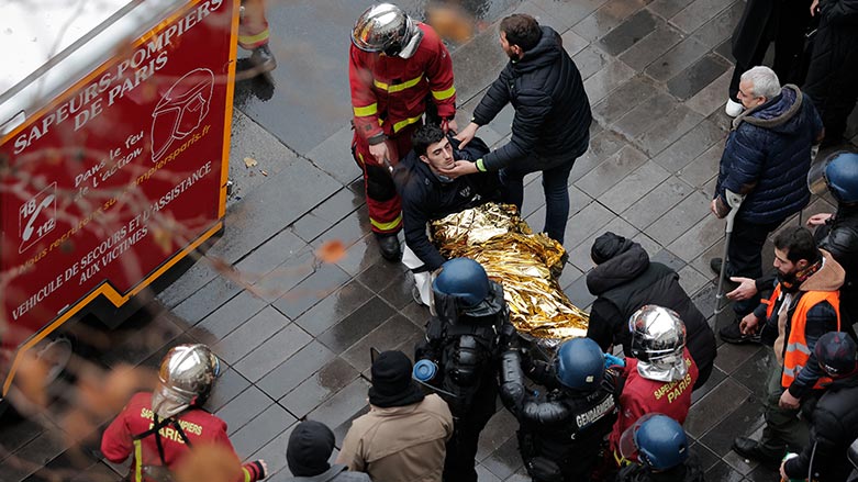 Fire brigade medics evacuating on a stretcher a wounded demonstrator during a protest against the recent shooting at the Kurdish culture center in Paris, Saturday, Dec. 24, 2022. (Photo: Lewis Joly/ AP)