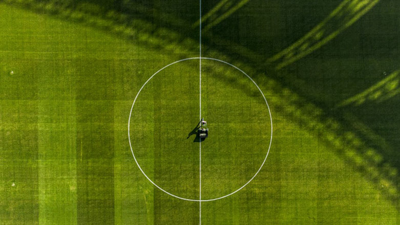 An aerial view of a worker mowing the turf of the pitch at the New Minaa Olympic Stadium, built to accomodate 30,000 spectators, in Iraq's southern city of Basra, Dec. 26, 2022. (Photo: Hussein Faleh/AFP)