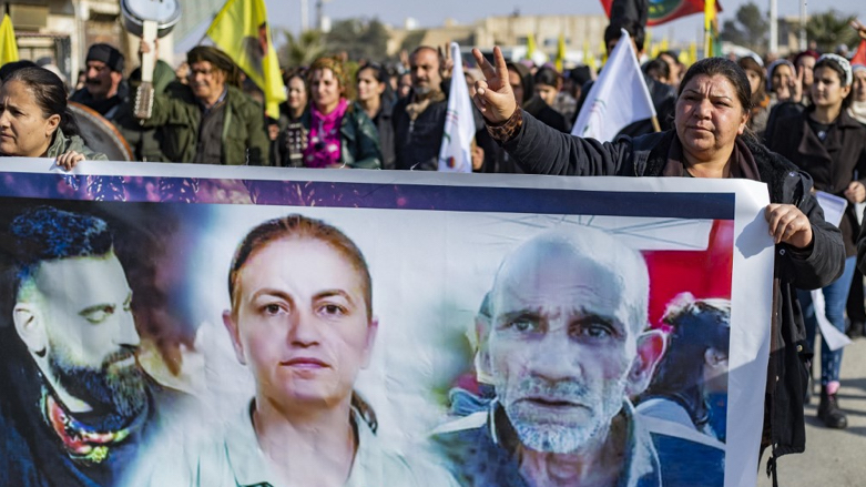 Syrian Kurds hold a banner featuring photos of three victims during a protest in Syria's northeastern city of Hasakeh on December 25, 2022 (Photo: DELIL SOULEIMAN / AFP)