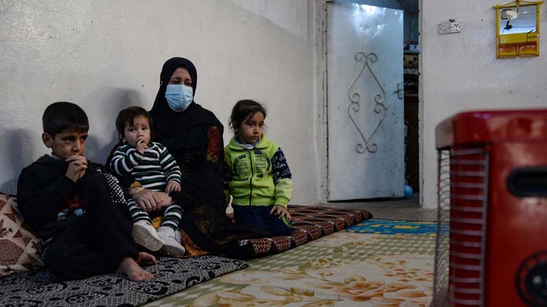 Alia Abdel-Razak, a woman deprived of crucial civil status documents, is pictured with 3 of her children in her home in Iraq's northern city of Mosul, Dec. 11, 2022. (Photo: Zaid Al-Obeidi/AFP)