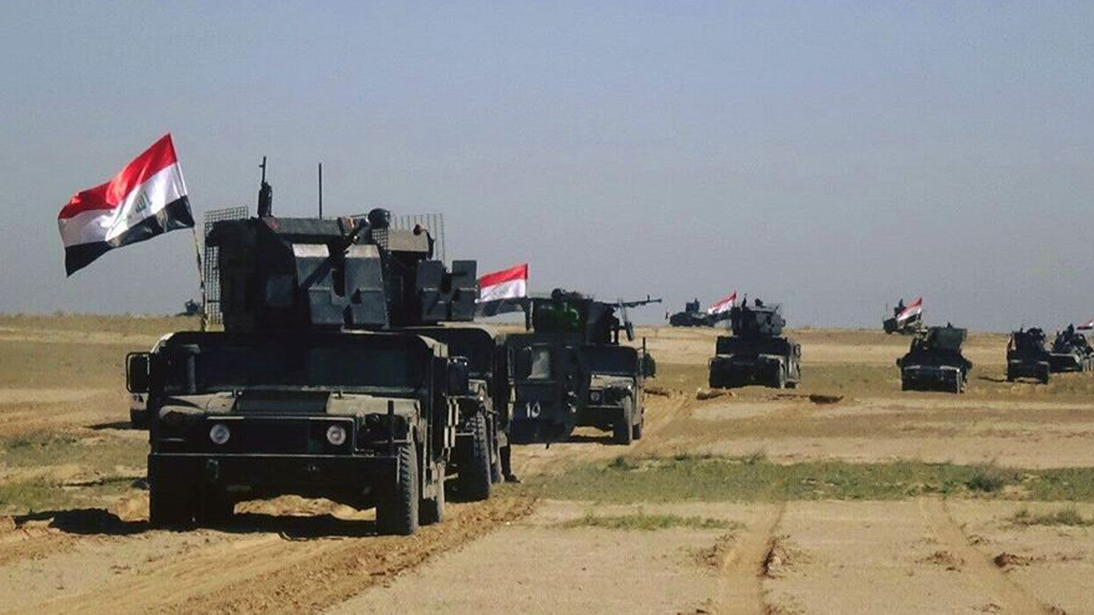 آليات عسكرية ترفع العلم العراقي