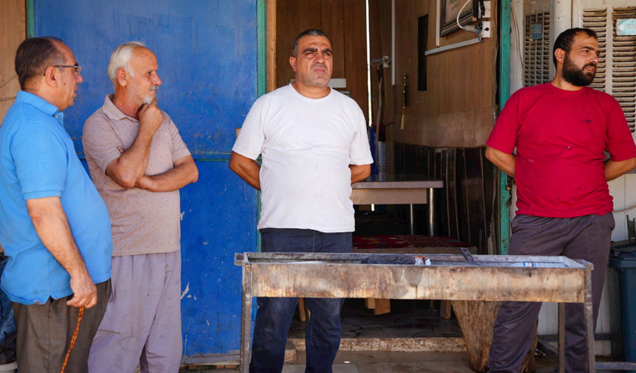 Syrian refugee shop owners standing in front of their businesses in Sumel district, Duhok. (Photo: Ahmed Kaka/NRC)