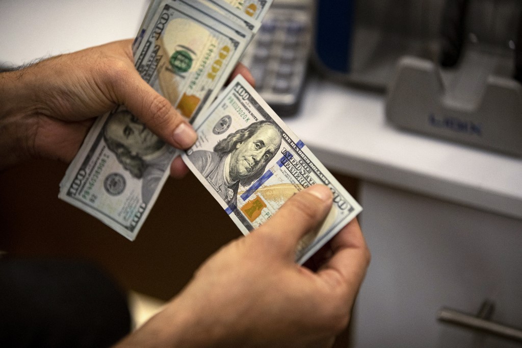 A currency exchange agent counts US Dollars at his company in Iraq's southern city of Basra, Dec. 8, 2023. (Photo: Hussein Faleh/AFP)