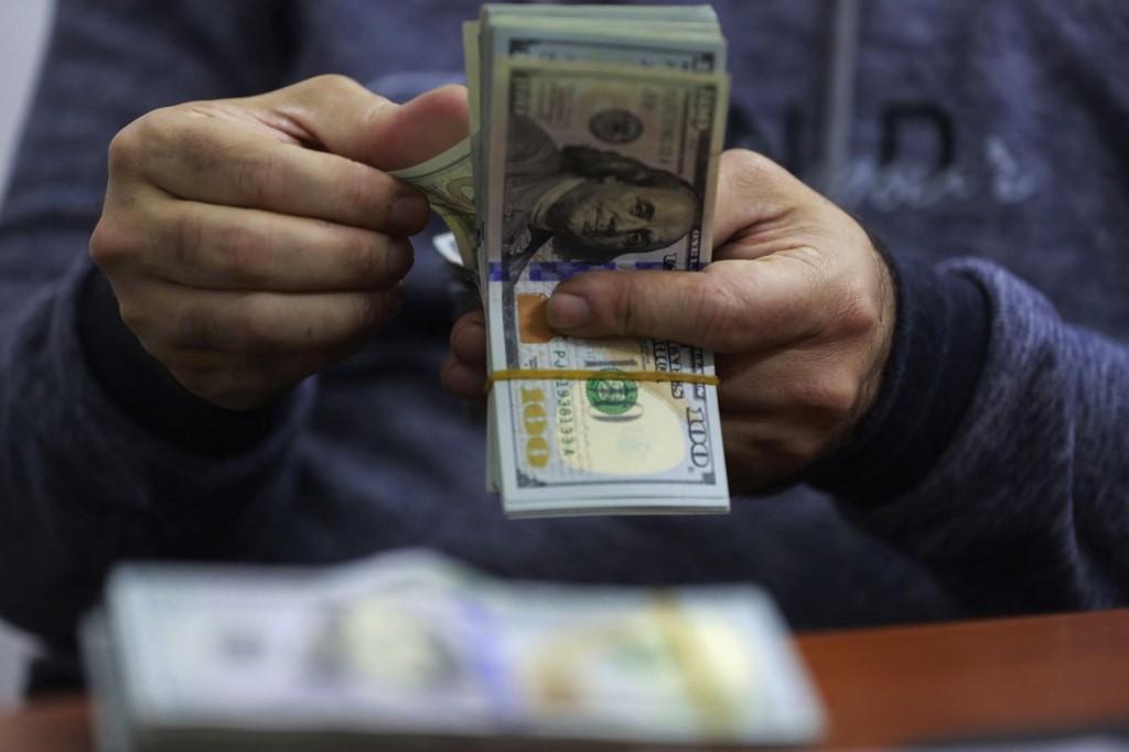 A currency exchange agent counts US Dollars at his company in Iraq's Baghdad, Dec. 12, 2023. (Photo: Ahmad Al-Rubaye/AFP)