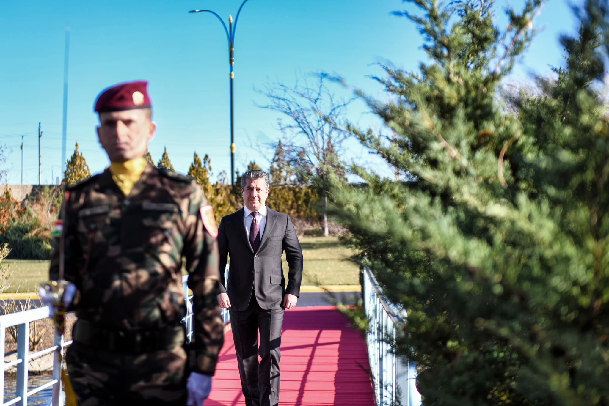 Kurdistan Region Prime Minister Masrour Barzani (right) is seen escorted by a Peshmerga officer at a flag-raising ceremony in Erbil to mark Kurdistan Region Flag Day, Dec. 17, 2023. (Photo: KRG)