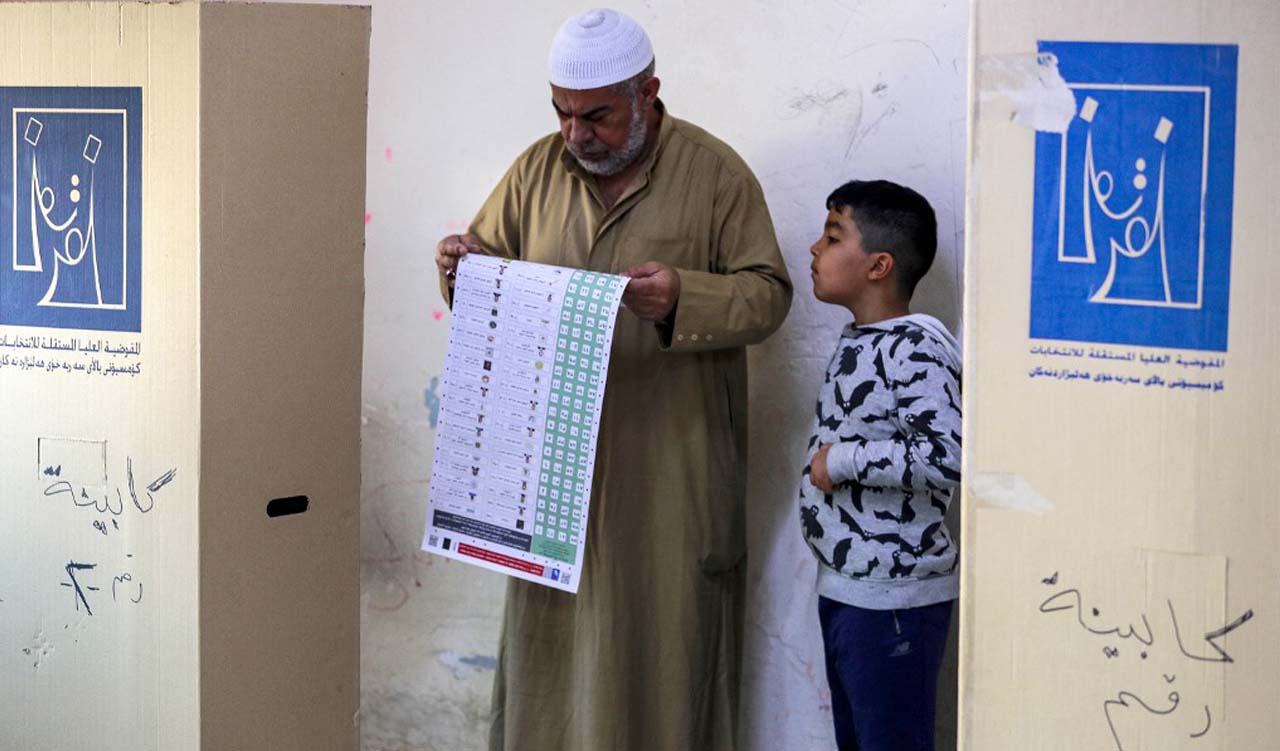 An elderly man holds his ballot while voting in the 2023 Iraqi provincial council elections, the first such vote in a decade, at a polling station in Sadr City in eastern Baghdad, Dec. 18, 2023. (Photo: Ahmad Al-Rubaye/AFP)