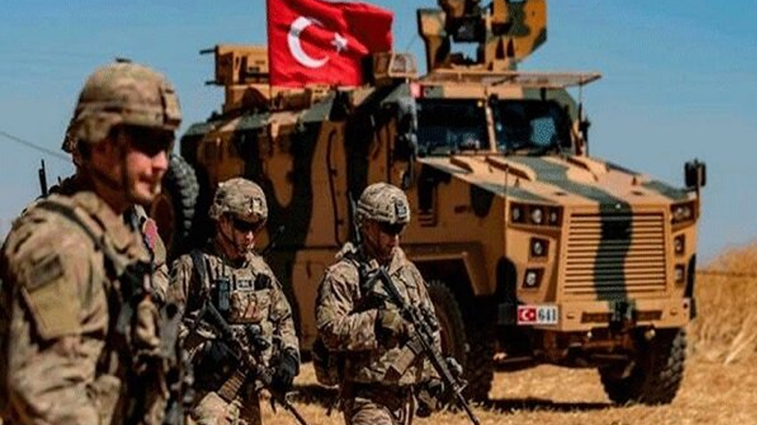 مدرعة ترفع العلم التركي وبجوارها جنود (وكالات)
